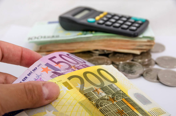 200 a 500 euro na pozadí kalkulačky a eurobankovek. Detailní záběr. - Fotografie, Obrázek