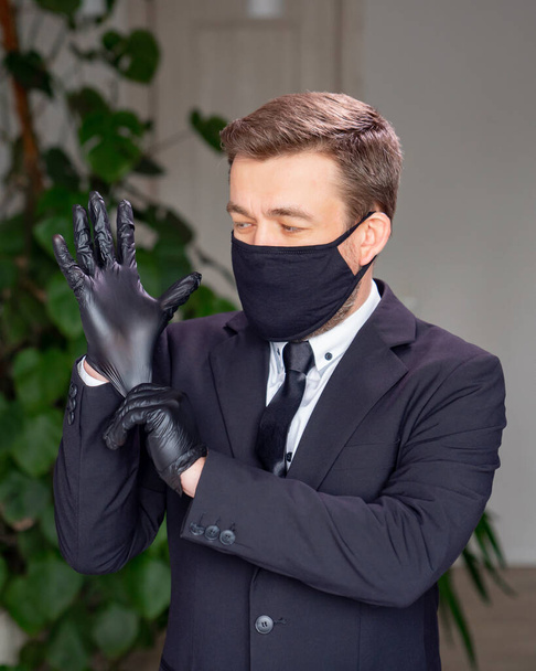 business man in suit and mask wearing black gloves - Fotoğraf, Görsel