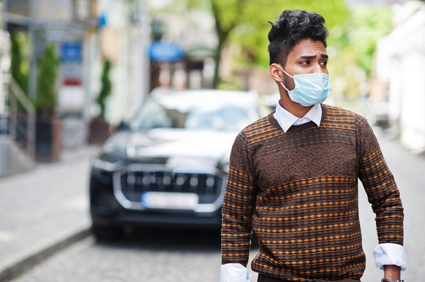 Coronavirus covid-19 concept. South asian indian man wearing mask for protect from corona virus posed against business car. - Fotografie, Obrázek