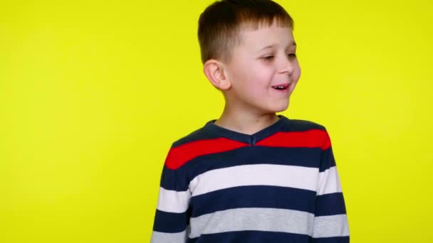 Παιδί αγόρι χαμογελά και λέει όχι σε ένα κίτρινο φόντο με αντίγραφο χώρο - Πλάνα, βίντεο