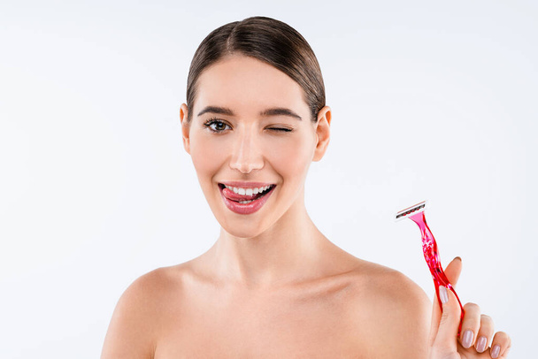 Young beautiful girl using shaver for depilation standing over isolated white background - Foto, imagen