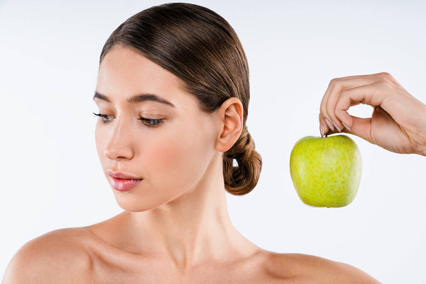 Beauty portrait of attractive woman posing with green apple standing isolated over white background - Fotografie, Obrázek