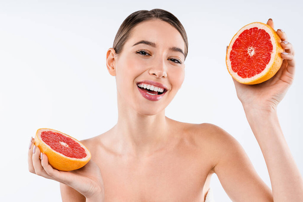 Happy young woman holding grapefruits isolated on white studio background - Photo, image