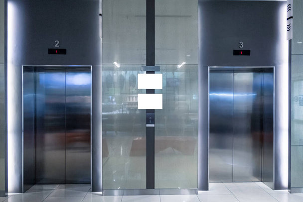 Closed two elevator doors glossy illuminated in lobby hotel - Fotó, kép