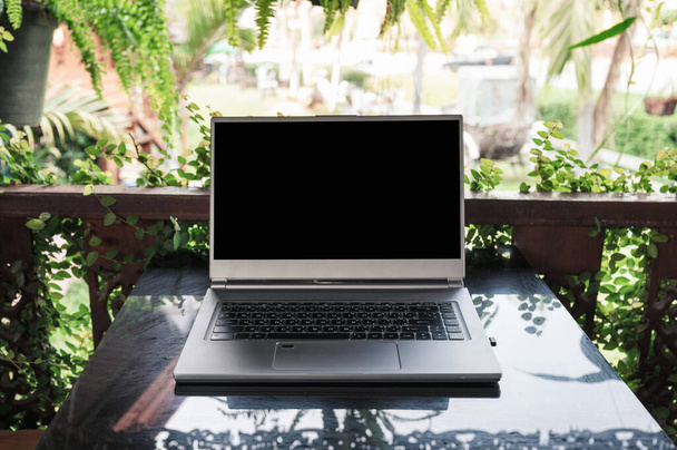 Abra o laptop cinza moderno na mesa de vidro no jardim da primavera no ensolarado
 - Foto, Imagem