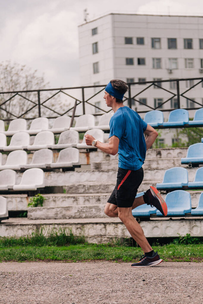 Nuori kaveri juoksee aamulla stadionilla harjoitus
 - Valokuva, kuva