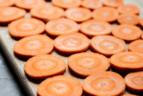 κοντινή προβολή φρέσκων ώριμων κομματιών καρότου σε ξύλο κοπής - Φωτογραφία, εικόνα