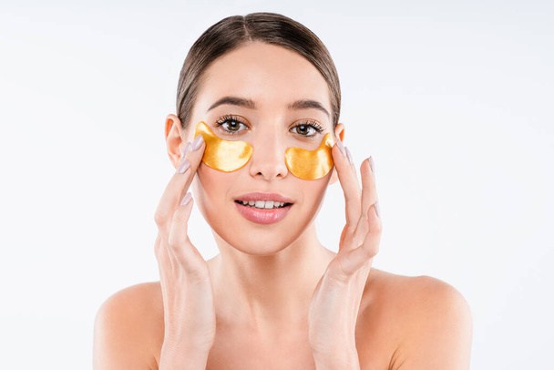 Beautiful naked lady putting under eyes patches for beauty spa procedures isolated over white background - Photo, image