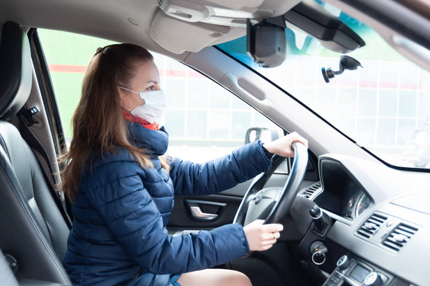 Vrouw in masker rijden auto - Foto, afbeelding