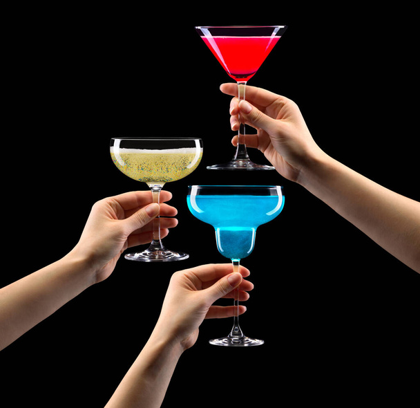 Set of hands holding cocktails isolated on black background - Photo, image