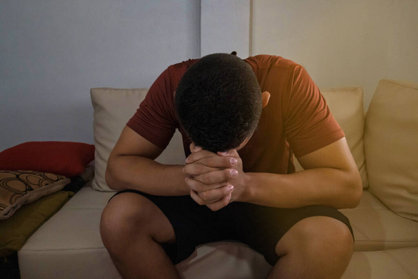 Dépression, désespoir et anxiété jeune homme assis seul et priant à la maison, distance sociale, santé mentale, santé des hommes
 - Photo, image