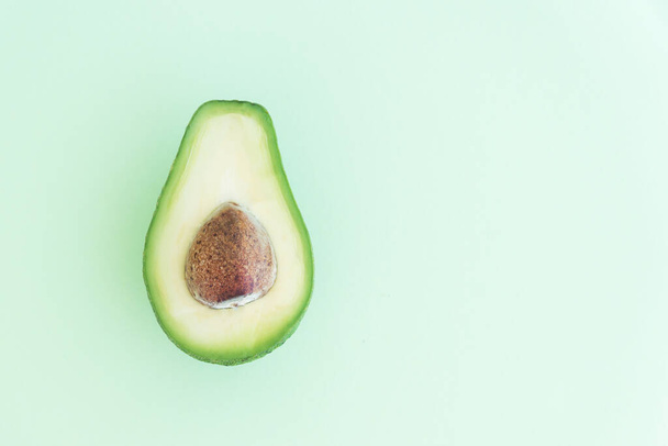  половина авокадо с ямой на светло-зеленом фоне, пространство для текста, концепция здорового питания, диеты и детоксикации питания
 - Фото, изображение