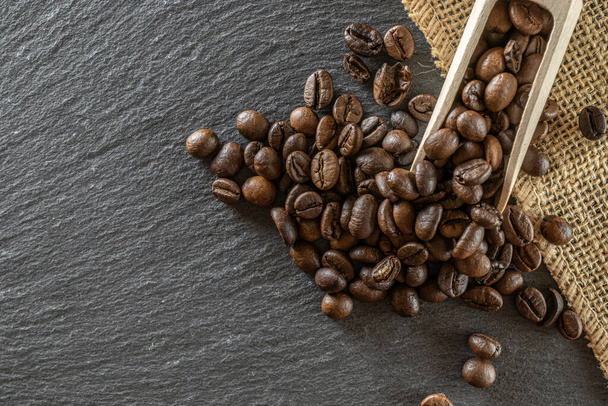 カフェコーヒーの背景。食品用エスプレッソ豆,黒でカフェインの朝食を飲む.エネルギーモカ、カプチーノ成分のために隔離された茶色のローストコーヒーの種。コピースペース,トップビュー. - 写真・画像