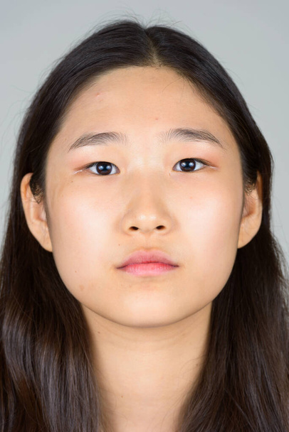 Studioaufnahme einer jungen schönen Koreanerin vor weißem Hintergrund - Foto, Bild