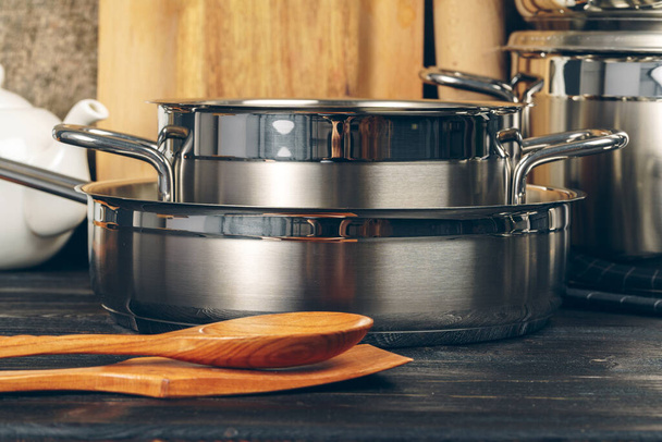 Set of stainless steel saucepans in a kitchen - Фото, зображення