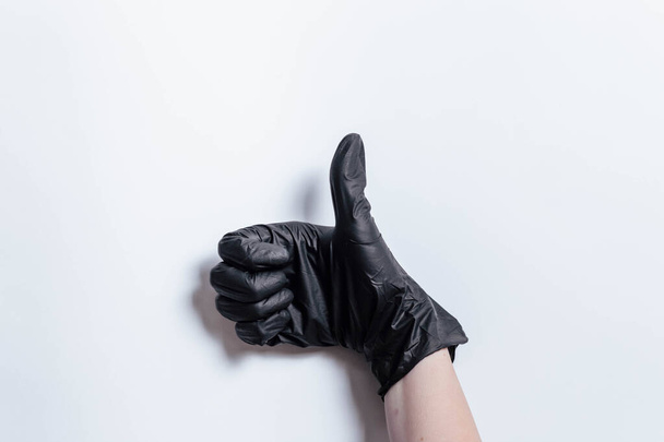 Рука в чорній медичній рукавичці, що показує клас. Клас показу рук
. - Фото, зображення