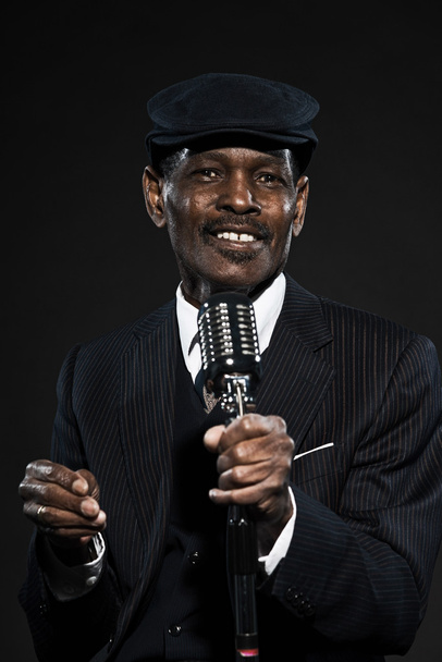 singender älterer afroamerikanischer Bluesman im Retro-Look. mit gestreiftem Su - Foto, Bild
