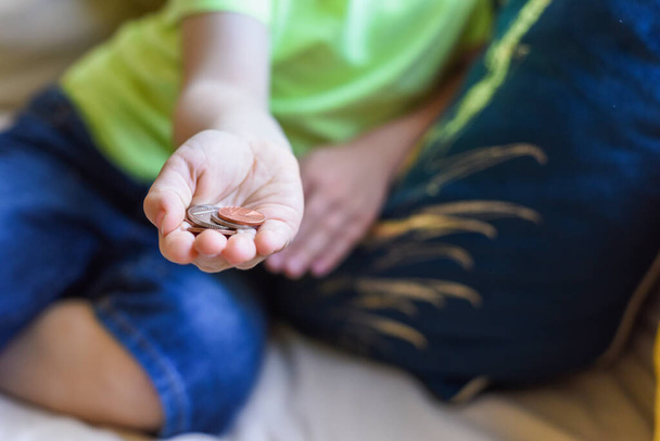 Kind houdt geld in de hand cash is Britse muntstukken - Foto, afbeelding