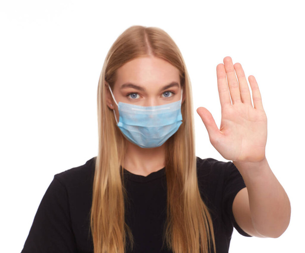 Chica que usa máscara para protegerse de la enfermedad y muestra gesto de manos detenidas para detener el brote del virus de la corona. Concepto de Coronavirus. - Foto, imagen