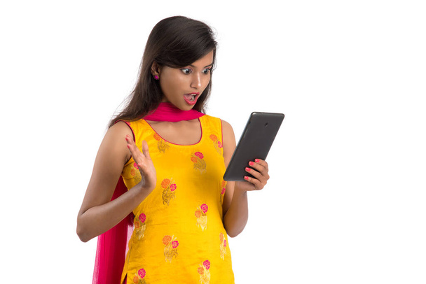 Young Indian girl using a mobile phone or smartphone isolated on a white background - Φωτογραφία, εικόνα