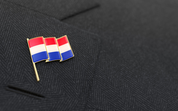 Pin de solapa de bandera holandesa en el cuello de un traje de negocios
 - Foto, imagen