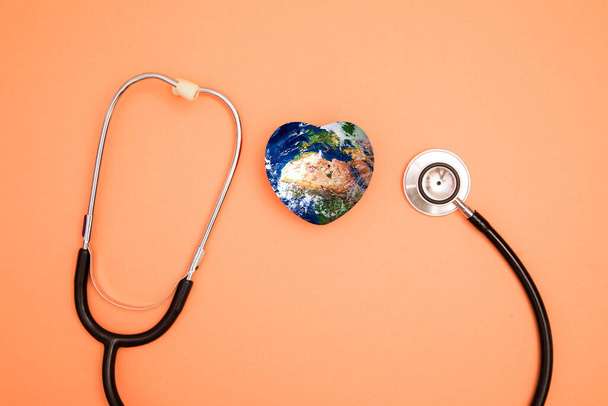 Stethoscope with globe on a red background.Headline - Foto, imagen