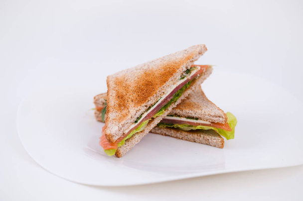 Sandwich de jamón en un plato sobre fondo blanco
 - Foto, imagen