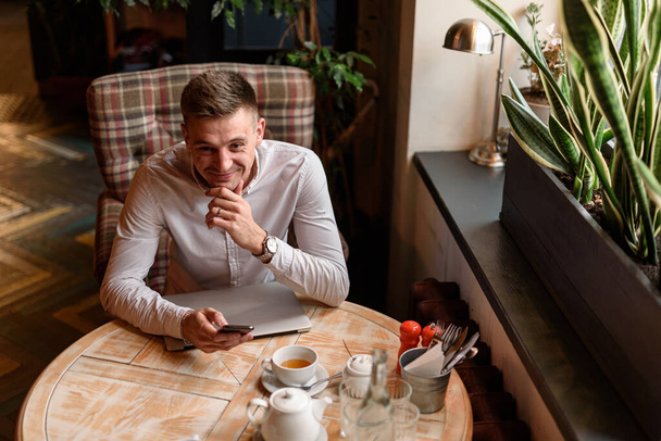 Lachende man lunchend in de koffieshop - Foto, afbeelding