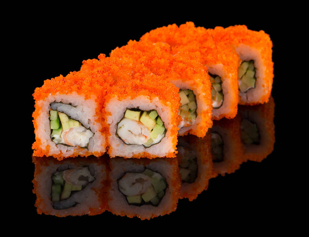 Sushi roll with shrimp, avocado, cucumber, cheese and tobiko caviar isolated on black background with reflection - Фото, зображення