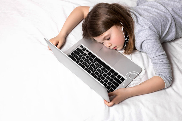 Tired child from distance learning at home. Transition to home schooling for children and teenagers. Home schooling and parents who teach children at home. Online education for kids during quarantine. - Photo, Image