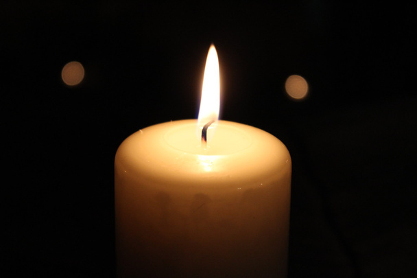Valaistu kynttilä mustalla taustalla
 - Valokuva, kuva