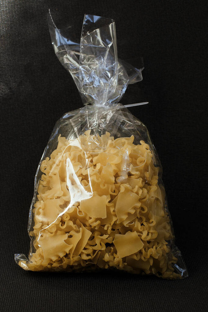 Pasta pakkaus malli eristetty mustalla taustalla. Raaka spagetti italialainen pasta keittämätön / raaka makaroni pakkauksessa vermicelli pasta tuote kuiva ruoka, pilaantumaton ruoka
 - Valokuva, kuva