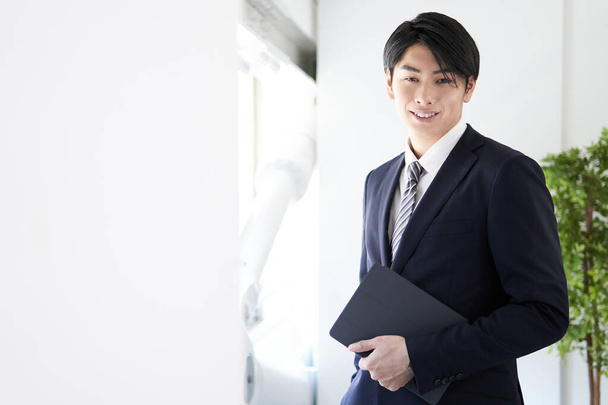 Japanse mannelijke zakenman glimlachen en kijken naar de camera - Foto, afbeelding