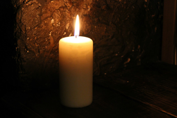 Valaistu kynttilä mustalla taustalla
 - Valokuva, kuva
