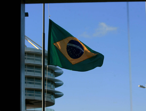 salvador, bahia / brazil - wrzesień 28, 2017: Flaga brazylijska wisi na maszcie w Centrum Administracyjnym Bahia w mieście Salvador. - Zdjęcie, obraz