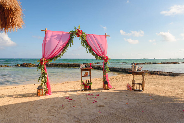 Hochzeitsbogen am Strand und tropischen Strand. Stoffe, Bambus, Dekor aus Blumen. - Foto, Bild