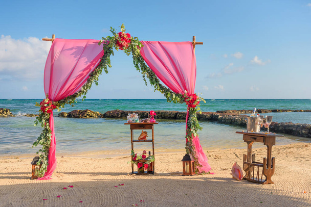 Γάμος αψίδα στην παραλία και τροπική παραλία. Υφάσματα, μπαμπού, διακόσμηση λουλουδιών. - Φωτογραφία, εικόνα