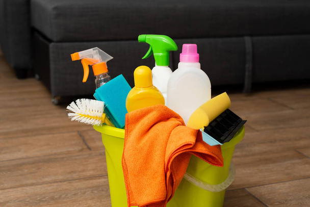 Um balde amarelo com detergente no chão. As limpezas estão no balde.. - Foto, Imagem