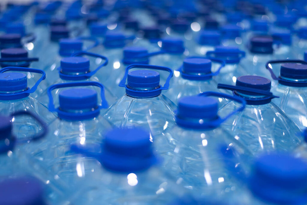 Un montón de botellas vale la pena con agua limpia y fresca natural. Grupo de botellas de plástico con soporte de agua en fila
. - Foto, Imagen