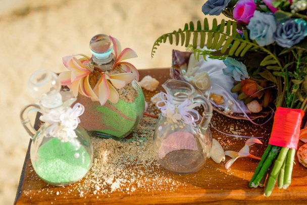 τελετή άμμου στο τραπέζι με ένα όμορφο μπουκέτο λουλούδια - Φωτογραφία, εικόνα