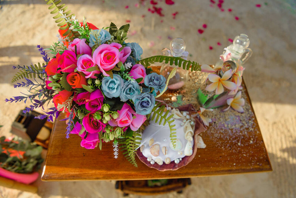 homok szertartás az asztalon egy gyönyörű csokor virággal - Fotó, kép