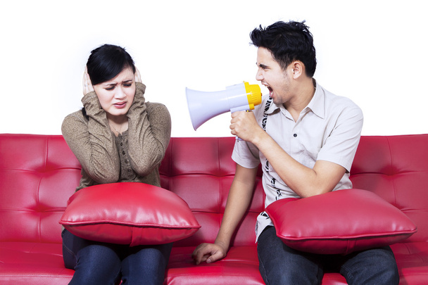 Angry boyfriend using speaker at girlfriend - Foto, imagen
