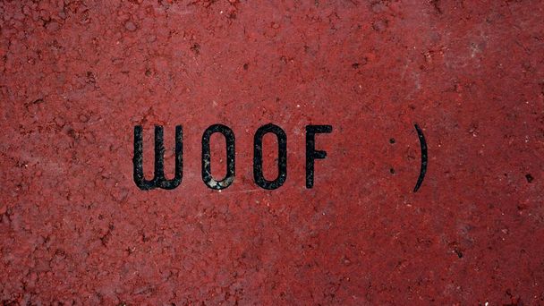"Woof "Uma declaração humorística gravada em tijolo vermelho
 - Foto, Imagem