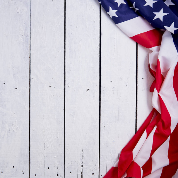Amerykańska flaga na obchody 4 lipca na białym drewnianym tle z okazji Dnia Niepodległości Ameryki. Zdjęcie zrobione z góry widok. - Zdjęcie, obraz