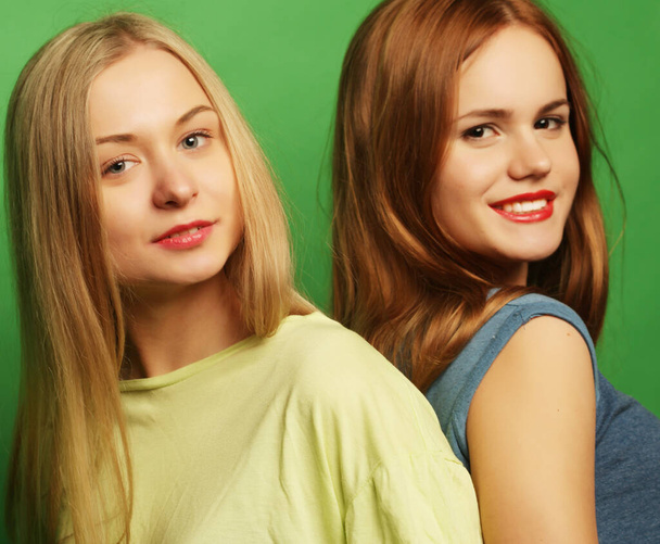 two hipster girls best friends over green background - Фото, зображення