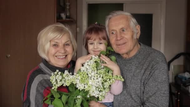 Enkelin umarmt lächelnden Großvater mit Großmutter zu Hause - Filmmaterial, Video