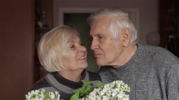 Egy boldog nagyapa és nagymama portréja. Nagymama csókolózik nagyapával. - Felvétel, videó