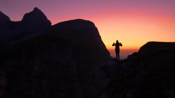 SILHOUETTE: Goldener Sonnenuntergang erleuchtet die Frau, die das Erreichen des Gipfels feiert. - Filmmaterial, Video