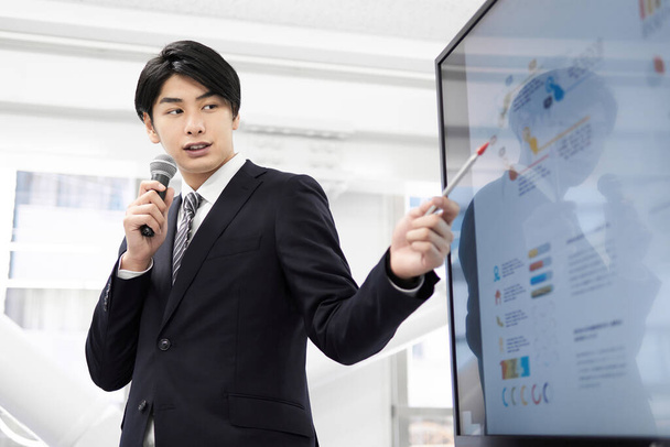 Ein japanischer Geschäftsmann bei einem Vortrag. - Foto, Bild