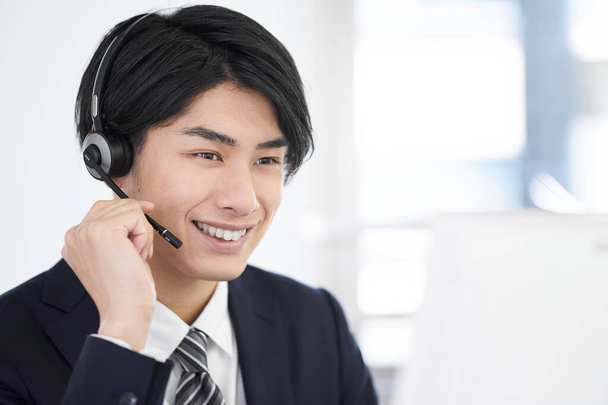 A call center man who answers with a smile. - Photo, Image